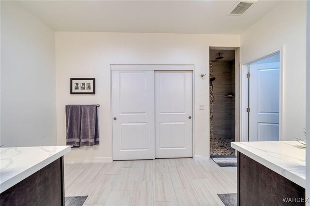 full bath featuring baseboards, visible vents, a shower stall, and vanity