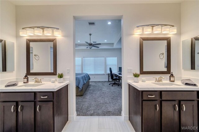 ensuite bathroom with a sink, a ceiling fan, visible vents, and connected bathroom