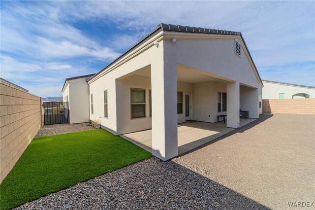 back of house featuring stucco siding, a fenced backyard, and a patio