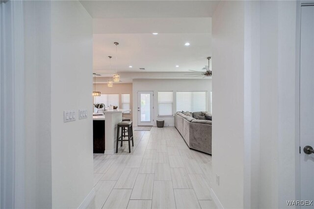 hallway featuring recessed lighting and baseboards