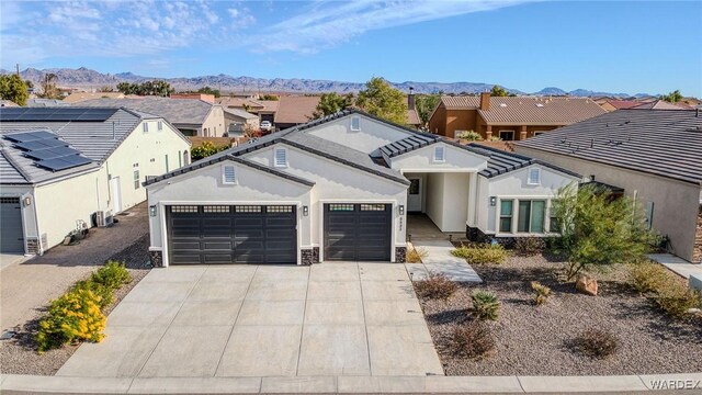 view of front of house with a mountain view, driveway, a residential view, and a garage