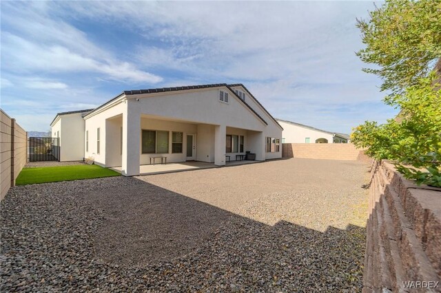 rear view of property with a patio area, a fenced backyard, and stucco siding