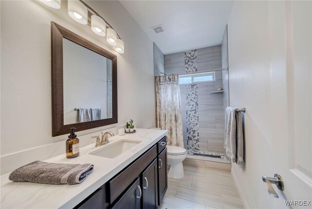 full bathroom featuring toilet, vanity, a shower stall, and visible vents