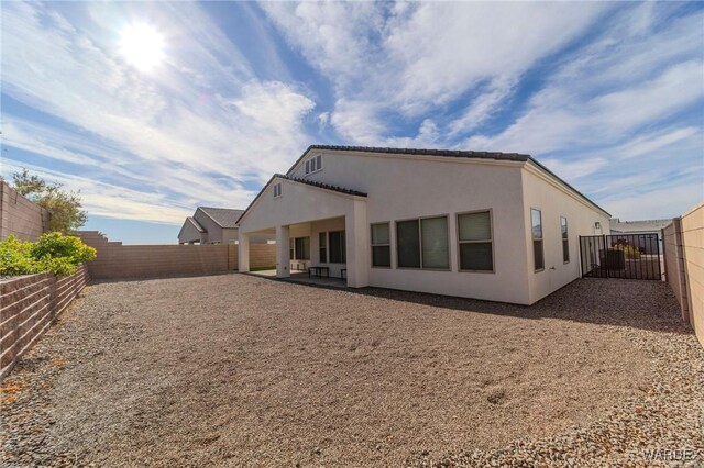 back of house featuring a patio area, a fenced backyard, and stucco siding