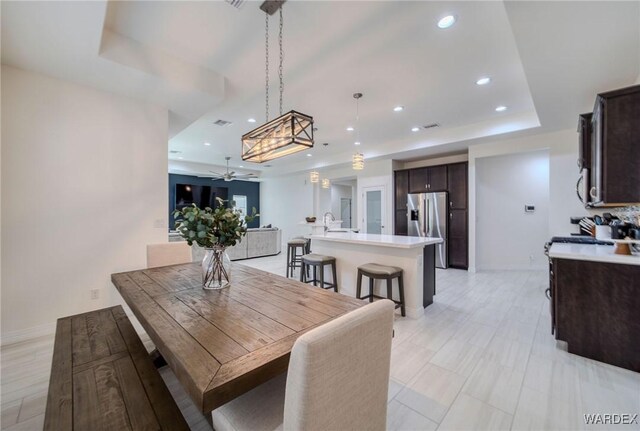 dining room featuring ceiling fan, baseboards, a raised ceiling, and recessed lighting