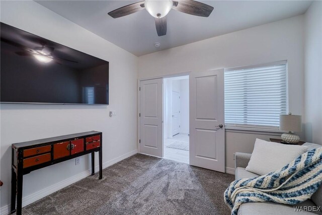 living area featuring ceiling fan, baseboards, and dark colored carpet