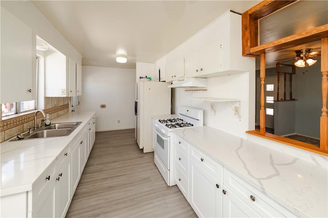 3345 W Smith Dr, Golden Valley, AZ 86413 - kitchen featuring white appliances, under cabinet range hood, a sink, decorative backsplash, and light wood-type flooring