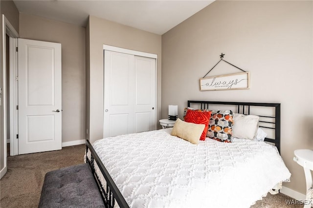 bedroom with baseboards, dark carpet, and a closet