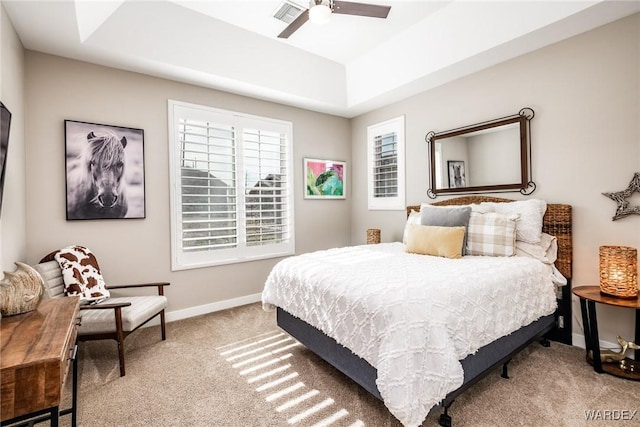 bedroom featuring a raised ceiling, carpet floors, a ceiling fan, baseboards, and visible vents