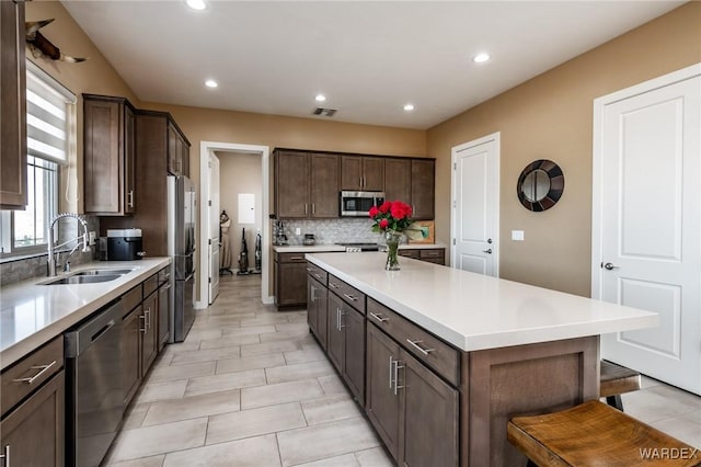 kitchen with stainless steel appliances, recessed lighting, decorative backsplash, and a sink
