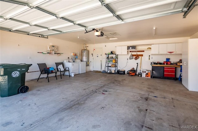 garage featuring a garage door opener, water heater, and washing machine and clothes dryer