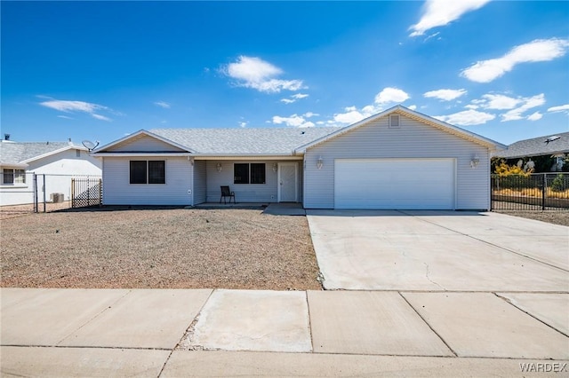 ranch-style house featuring a garage, concrete driveway, and fence