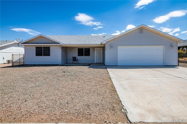 ranch-style house featuring a garage, driveway, and fence