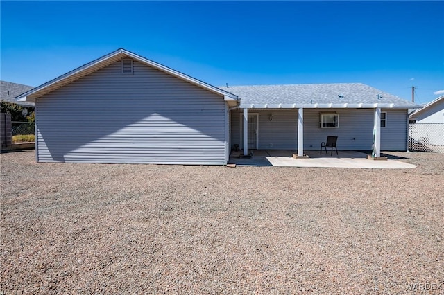 rear view of property featuring a patio and fence