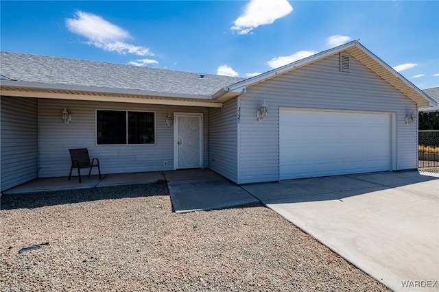 view of front facade with an attached garage, driveway, and roof with shingles