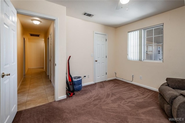 sitting room featuring baseboards, carpet floors, visible vents, and tile patterned floors