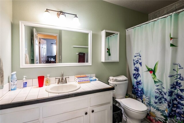 full bath with toilet, curtained shower, and vanity