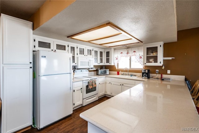 kitchen with white appliances, glass insert cabinets, white cabinets, and light countertops