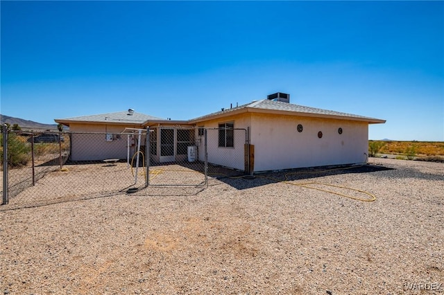 rear view of property featuring central AC and fence