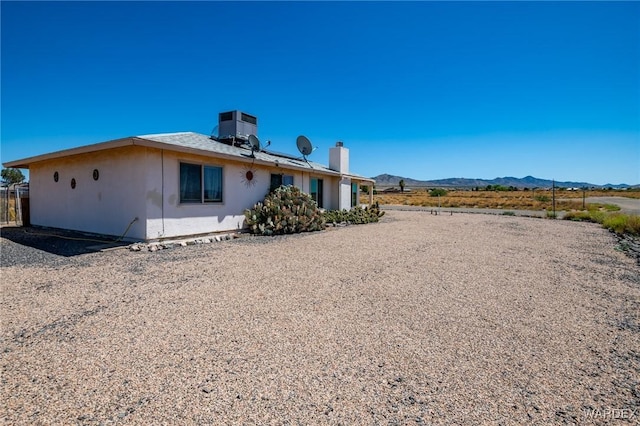 back of property featuring central air condition unit and a mountain view