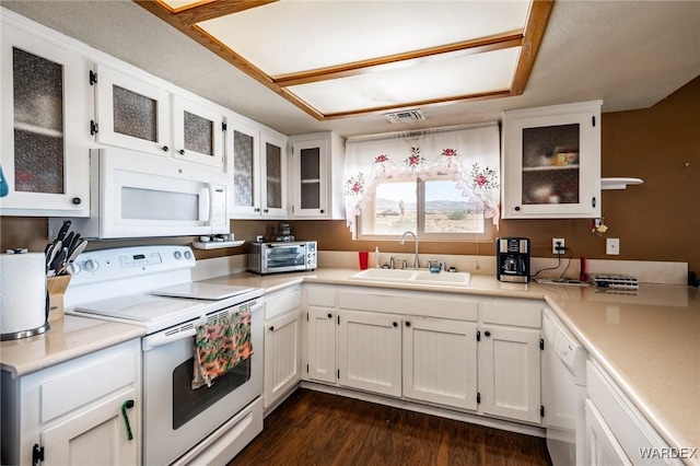 kitchen with light countertops, glass insert cabinets, white cabinetry, a sink, and white appliances