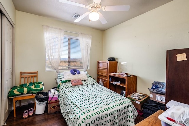 bedroom with a closet, visible vents, ceiling fan, and dark wood-style flooring