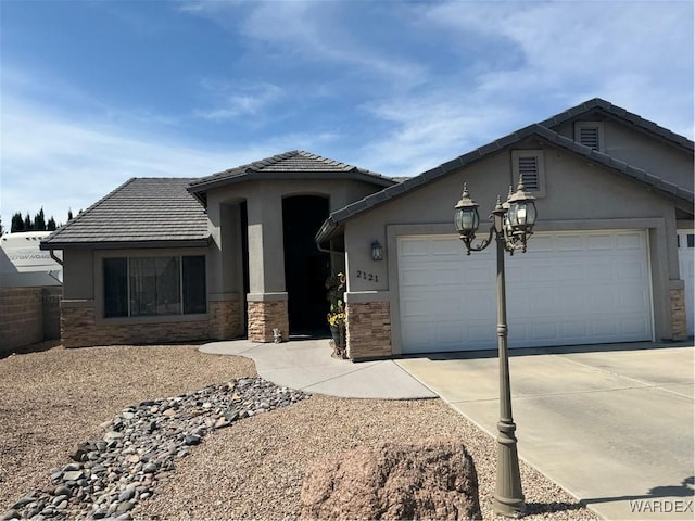 view of front of house with concrete driveway, stone siding, an attached garage, and a tile roof