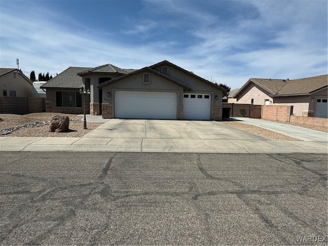 view of front facade with stone siding, a garage, fence, concrete driveway, and stucco siding