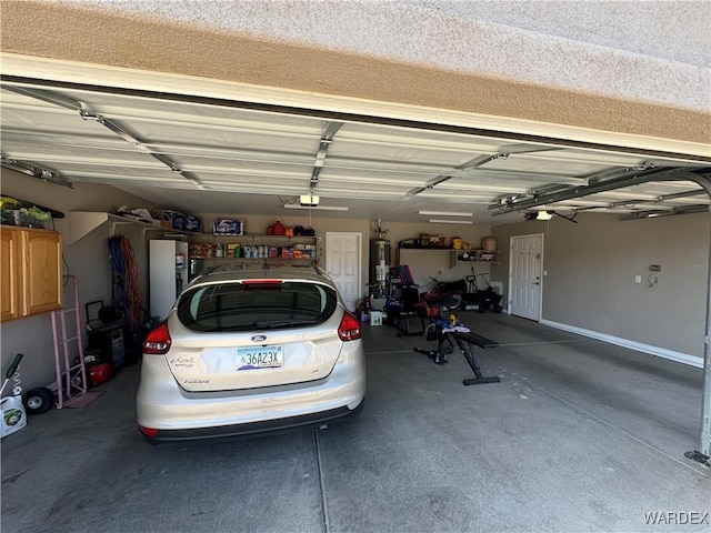 garage featuring water heater and a garage door opener