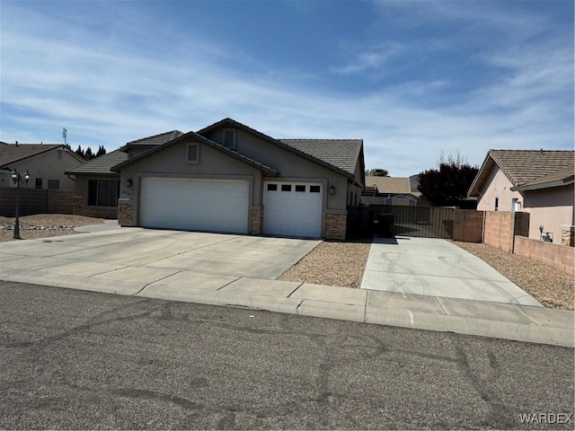 view of front of property with an attached garage, fence, stucco siding, and concrete driveway
