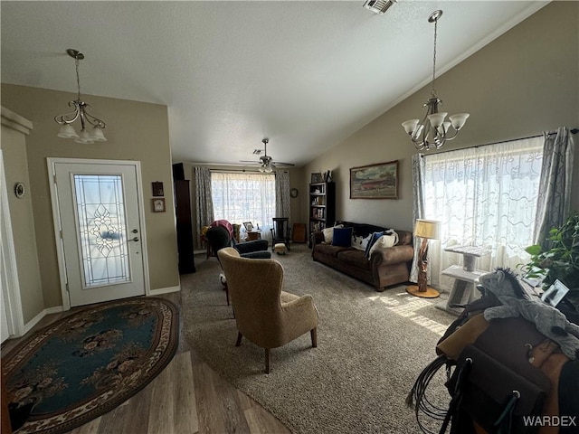 living area featuring baseboards, an inviting chandelier, and vaulted ceiling