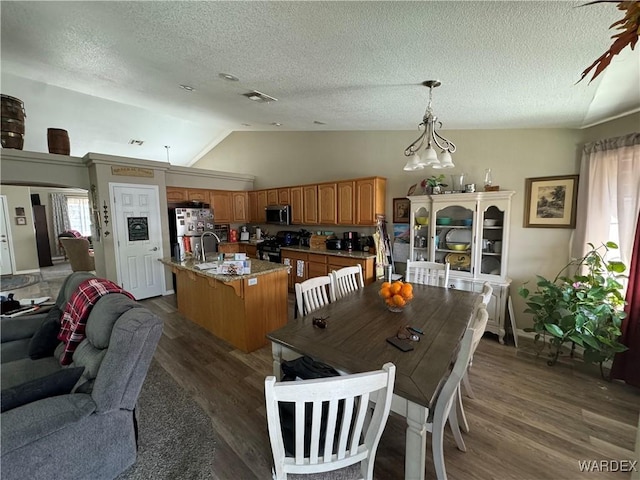 dining space with visible vents, an inviting chandelier, dark wood finished floors, a textured ceiling, and lofted ceiling