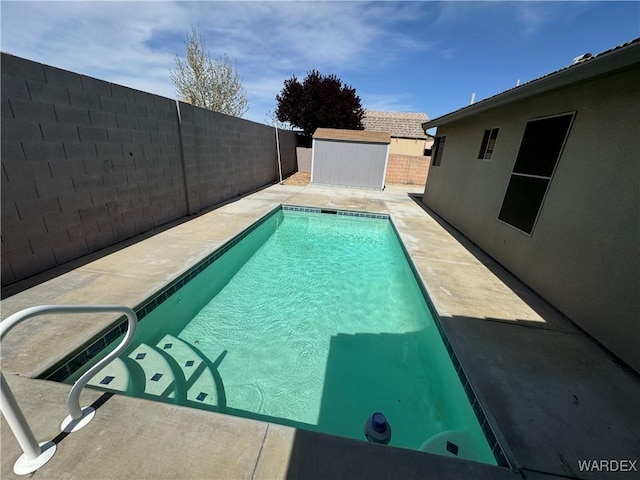 view of swimming pool with a fenced backyard, a fenced in pool, a patio area, and an outdoor structure