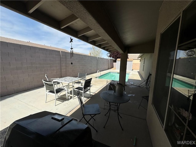 view of patio / terrace featuring a fenced backyard, a fenced in pool, and outdoor dining area