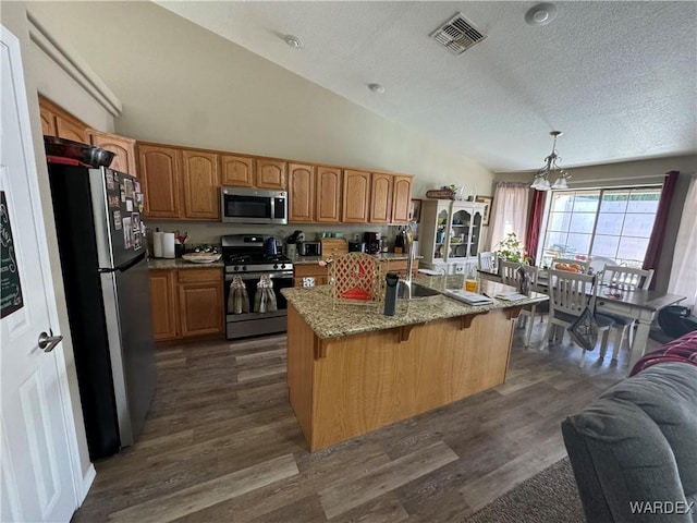 kitchen featuring dark wood finished floors, visible vents, appliances with stainless steel finishes, a sink, and a notable chandelier