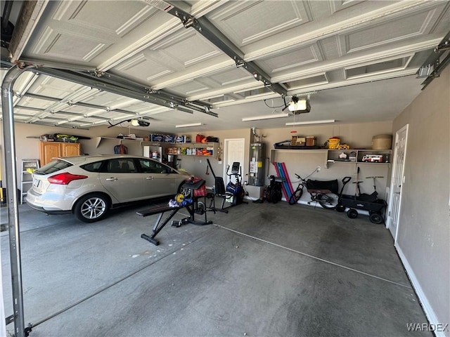 garage featuring water heater, baseboards, and a garage door opener