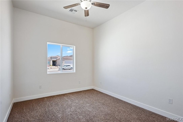 empty room with carpet, visible vents, and baseboards