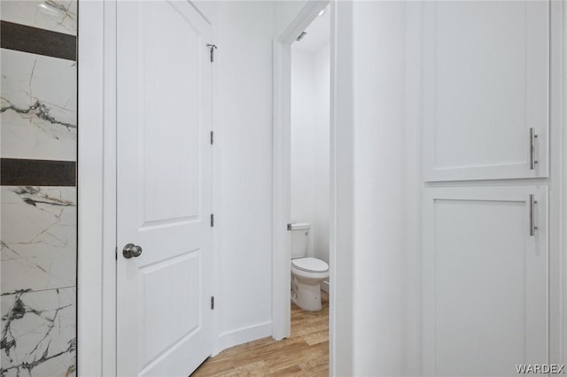 bathroom with toilet and wood finished floors