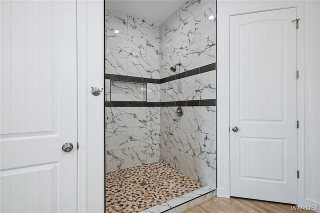 bathroom with a shower stall and wood finished floors