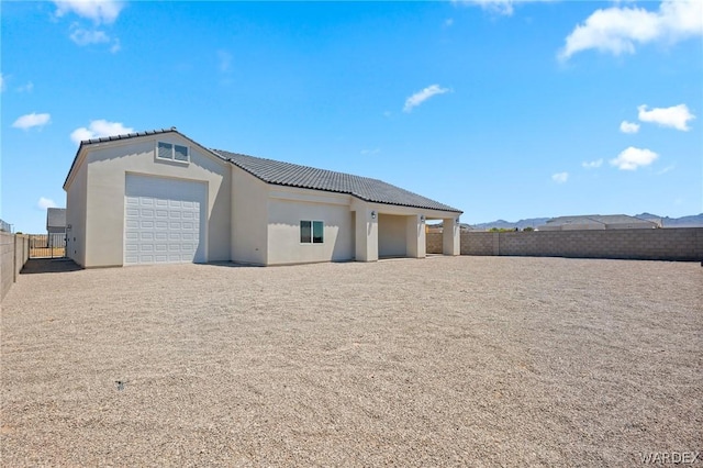 exterior space with a tile roof, fence, and stucco siding