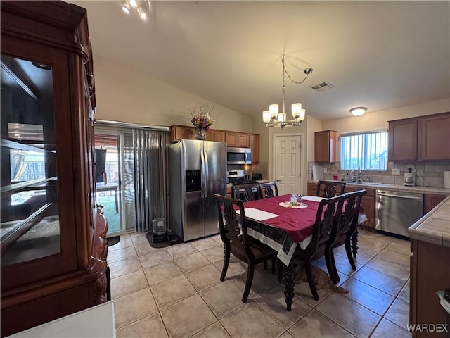 1481 E Topaz Cir Unit 2, Fort Mohave, AZ 86426 - dining space with lofted ceiling, a chandelier, visible vents, and light tile patterned flooring