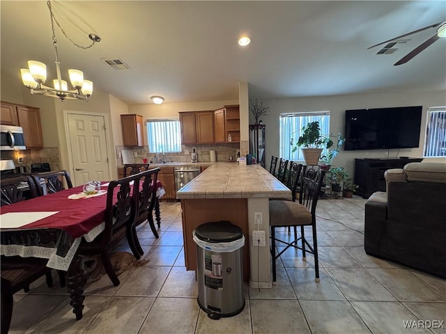 1481 E Topaz Cir Unit 2, Fort Mohave, AZ 86426 - dining space with ceiling fan with notable chandelier, light tile patterned floors, and visible vents