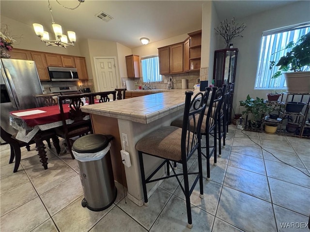 1481 E Topaz Cir Unit 2, Fort Mohave, AZ 86426 - kitchen featuring stainless steel appliances, open shelves, visible vents, tile counters, and light tile patterned floors