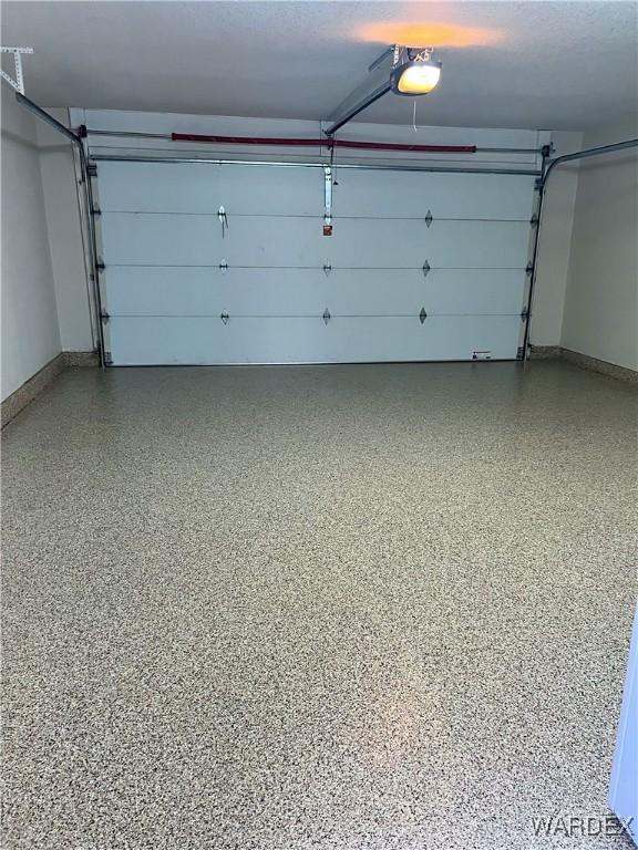 garage with baseboards and a garage door opener