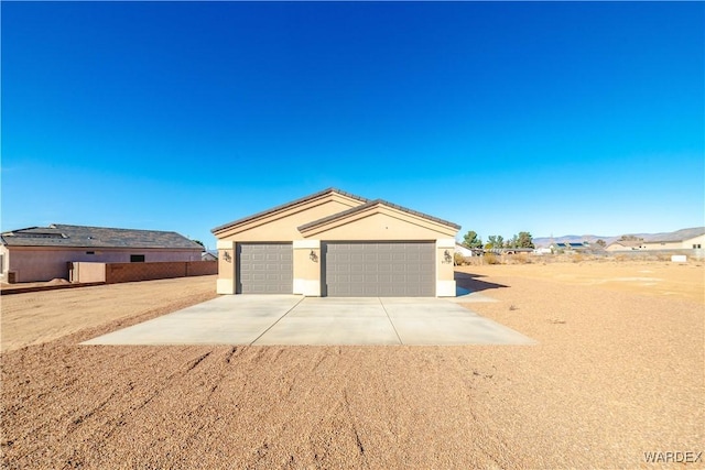 view of front of home featuring driveway, an attached garage, and stucco siding