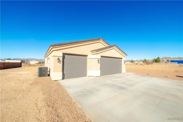 garage featuring driveway and cooling unit