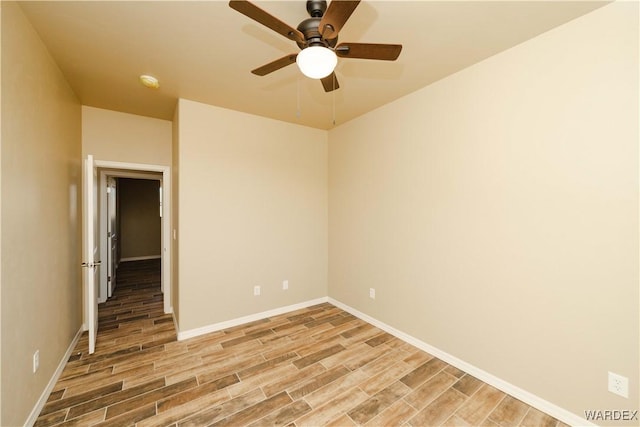 unfurnished room featuring baseboards, a ceiling fan, and light wood-style floors