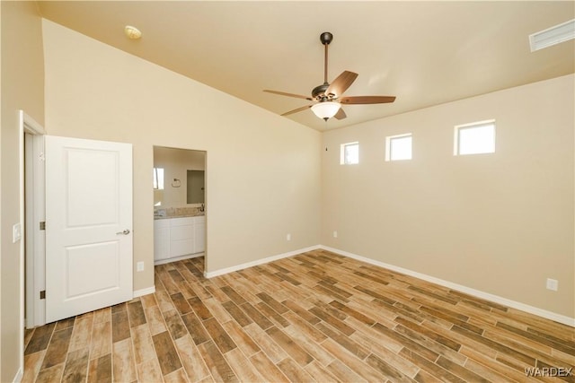 spare room featuring baseboards, visible vents, a ceiling fan, lofted ceiling, and light wood-type flooring