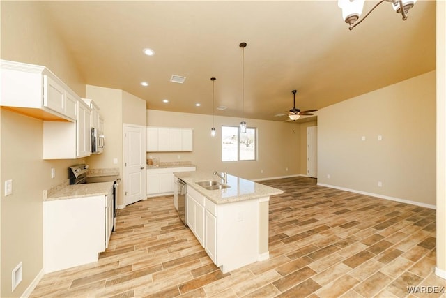 kitchen with ceiling fan, appliances with stainless steel finishes, wood finish floors, white cabinetry, and a sink