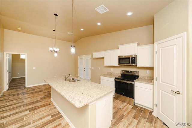 kitchen with stainless steel appliances, wood tiled floor, visible vents, and a sink